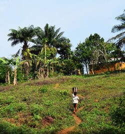 African child walking up the trail to a village