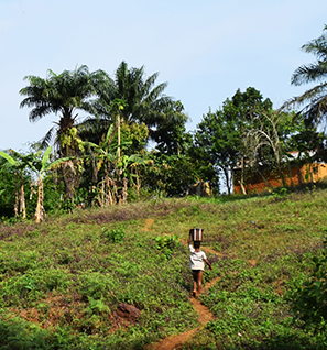 African child walking up the trail to a village
